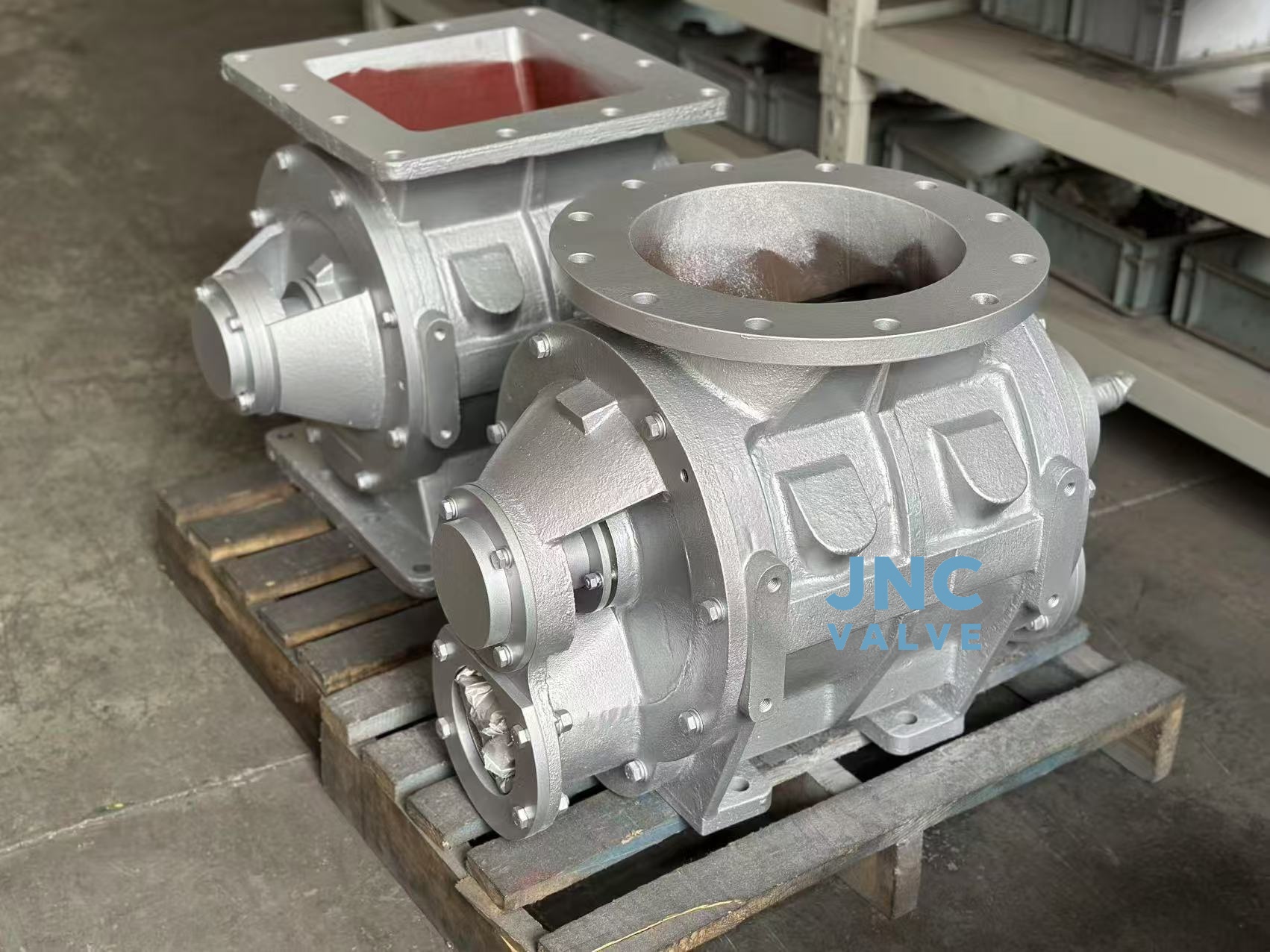 How effective is a rotary valve in reducing dust leakage when handling dusty materials like cement or sand?